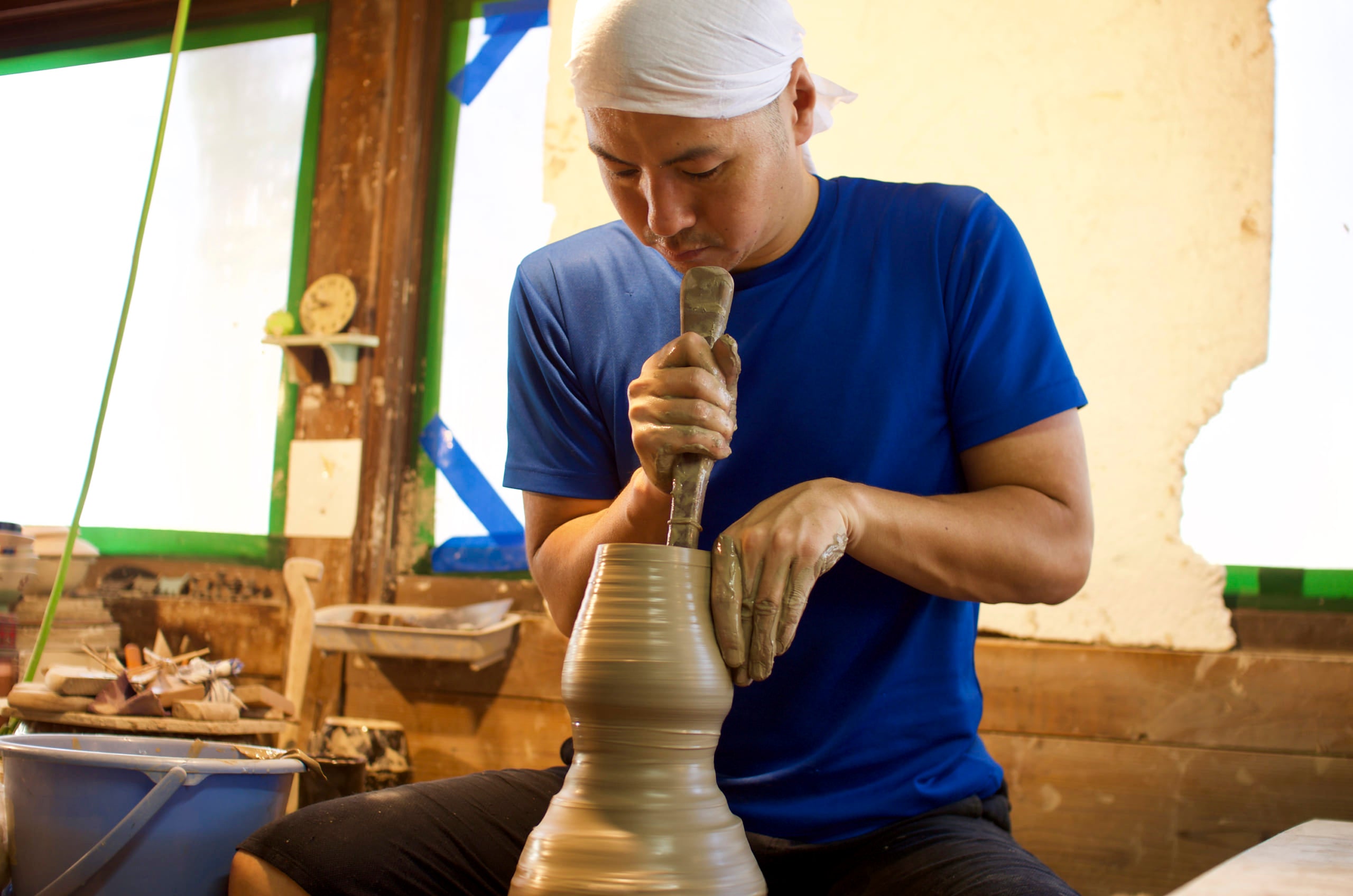 Shaping a pot on a kick wheel